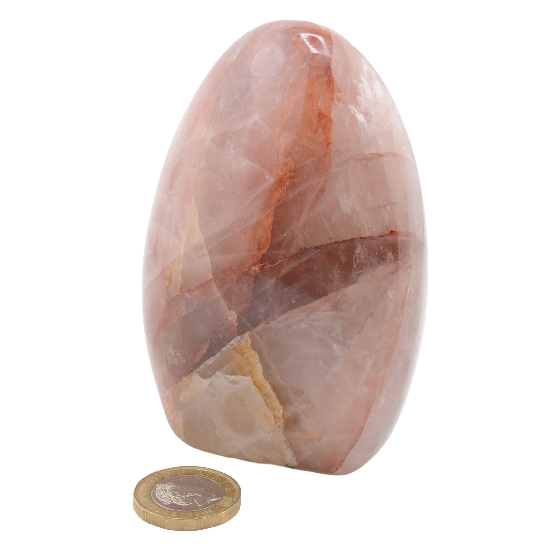 A polished fire quartz crystal freeform with natural marbling and brown veining, shown next to a gold coin for scale on a white background.