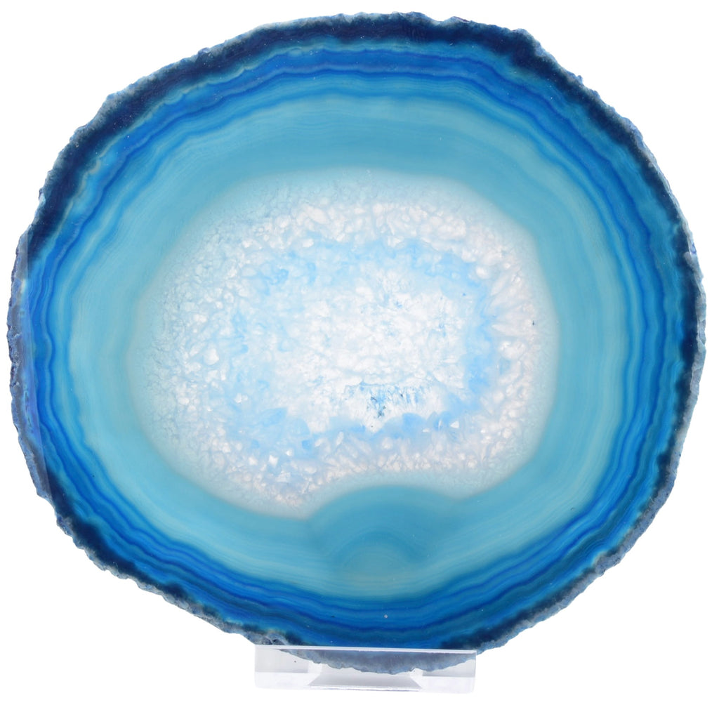 A round agate slice with concentric bands of deep blue, medium blue, and a frosted white center, displayed upright on a small clear stand against a white background.