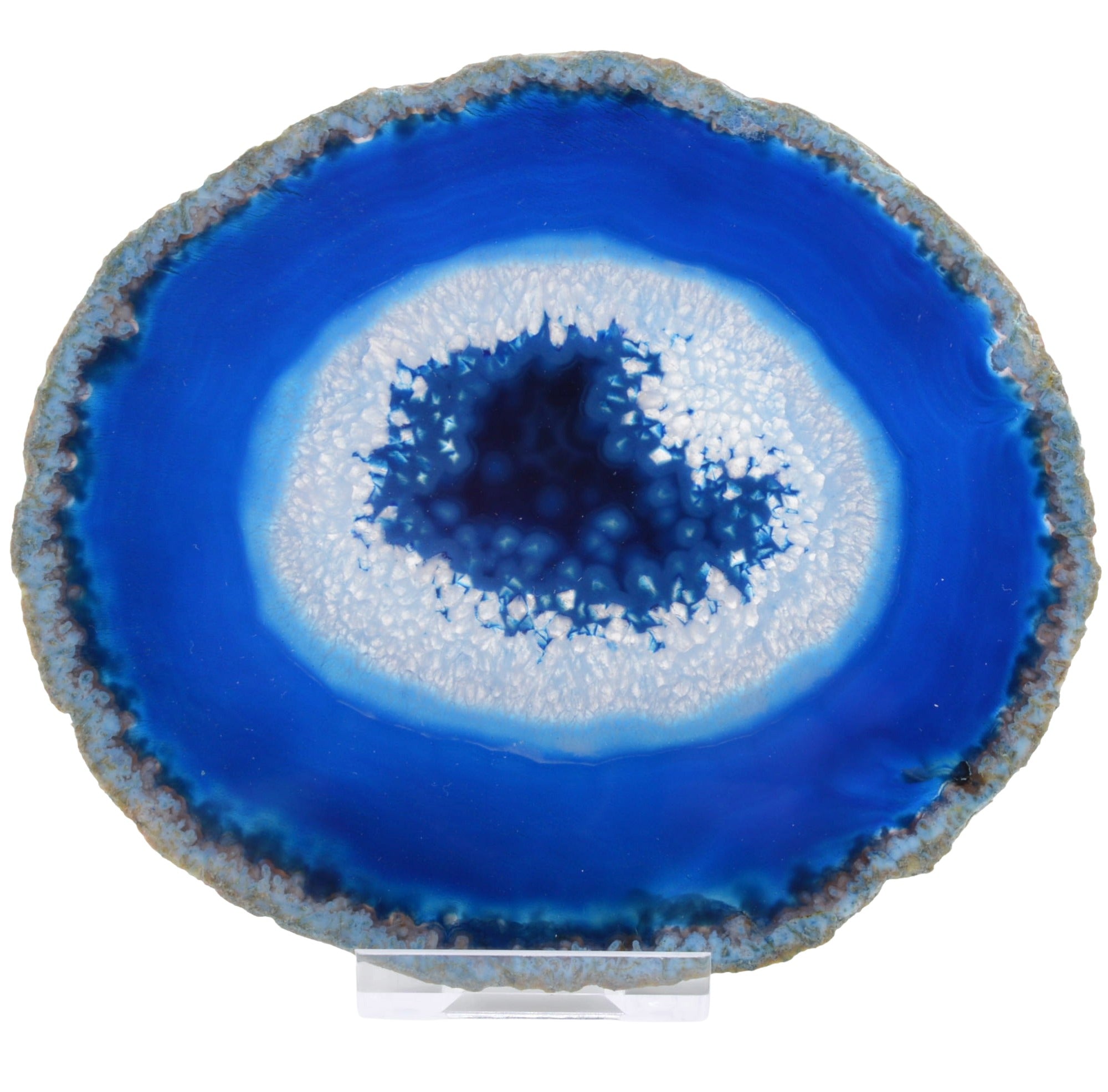 A polished agate or geode-style decorative slice with concentric rings of deep blue, white, and gray-brown crystalline edges, displayed upright on a small clear stand against a white background.