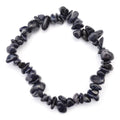 A beaded stretch bracelet made of small, dark polished stone chips of blue goldstone arranged in a circular shape on a plain white background.