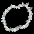 A beaded stretch bracelet made of irregular, translucent white to light blue opal-like stones, displayed on a dark textured background.