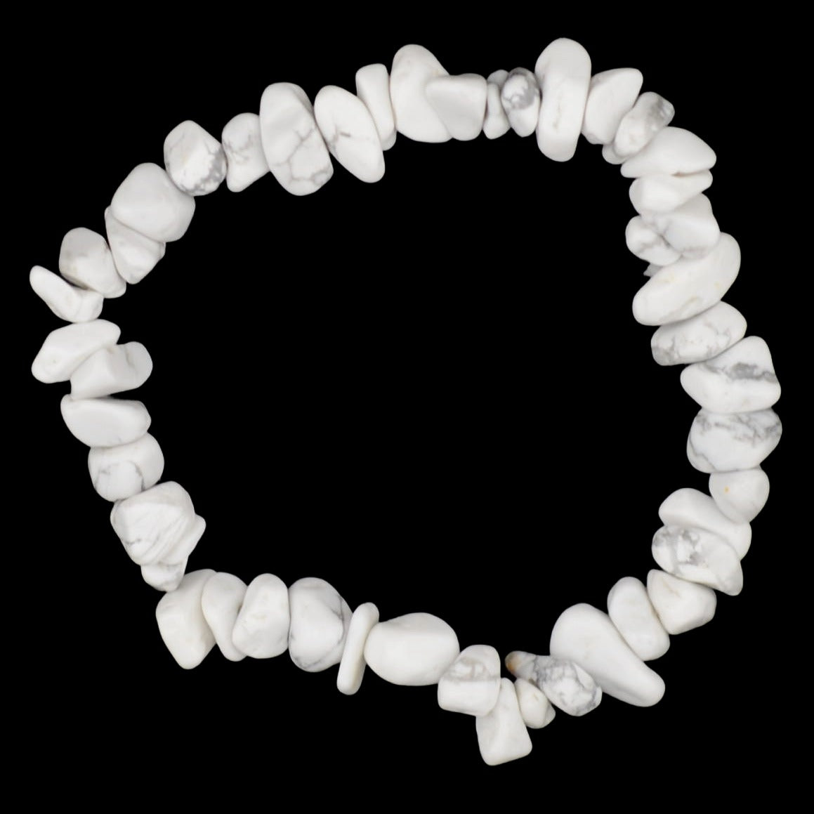 A white howlite gemstone chip bracelet in white with grey veining, arranged in a circle on a dark textured background.